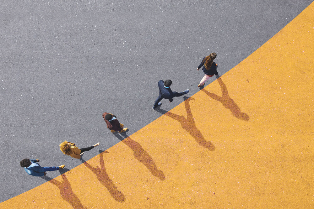 A bird’s-eye view of five people walking in a line along the floor.