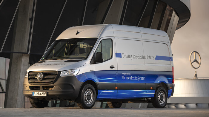 Ein weiß-blauer Transporter von Mercedes-Benz mit der englischsprachigen Aufschrift Driving the electric future.