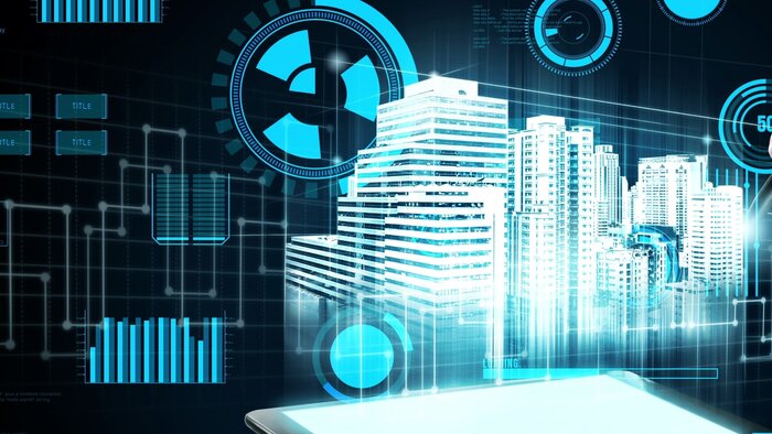 Eine digitale Visualisierung einer futuristischen Stadt mit Hochhäusern, drumherum sind blaue Daten-Overlays eingeblendet.