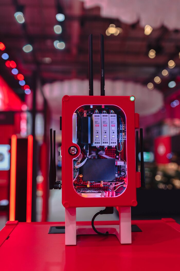 Ein rotes mit sichtbarer Elektronik und Antennen steht auf einer roten Oberfläche.