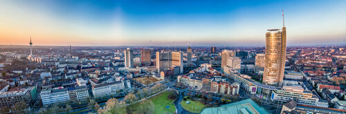 Ein Panoramablick auf die Stadt Essen, der auch hohe Gebäude, einen Park und den Horizont zeigt.