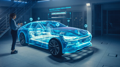 Eine Frau in einer futuristischen Werkstatt betrachtet ein das Hologramm eines Autos und virtuelle Datenanzeigen.