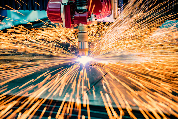 Ein Laser verarbeitet Material, dabei entstehen viele Funken.