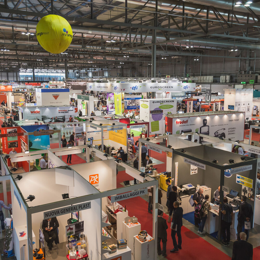 A view across many exhibition stands in an exhibition hall.