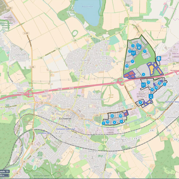 Eine kartografische Darstellung der Stadt Eschweiler und Umgebung mit markierten Gewerbe- und Industrieflächen sowie Symbolen für Einrichtungen.
