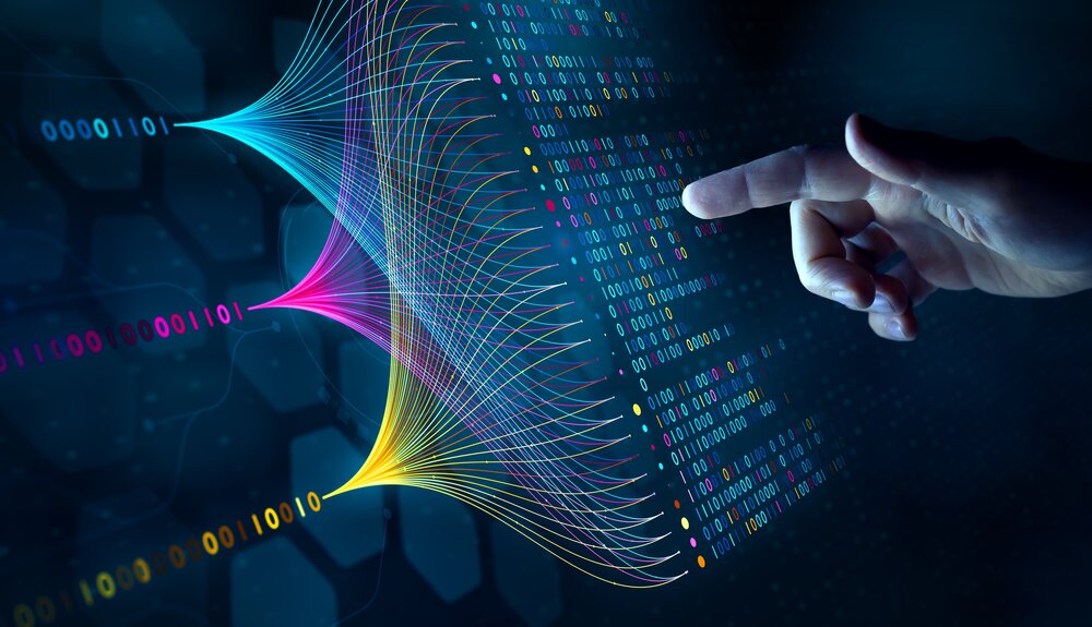 A hand points to a digital interface with vibrant, multicolored neural network patterns and binary code, suggesting artificial intelligence and data analysis.