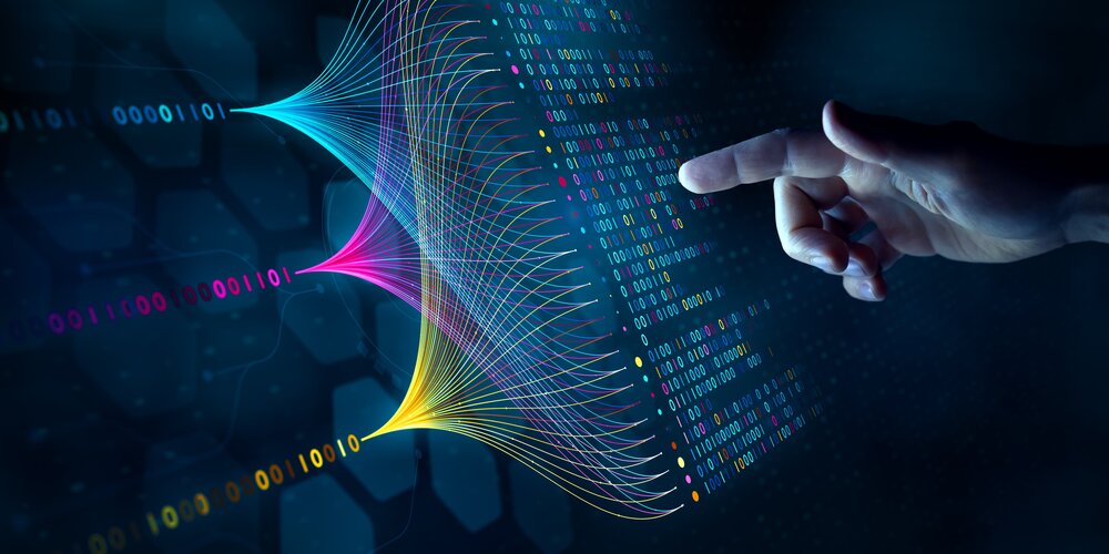 Eine Hand zeigt auf eine digitale Benutzeroberfläche mit lebhaften, bunten Mustern eines neuronalen Netzwerks und Binärcode, was auf künstliche Intelligenz und Datenanalyse hindeutet.